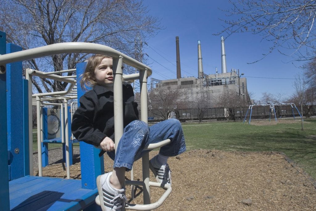 Girl on playground near power plant